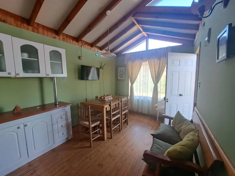 Interieur lumineux avec cuisine, table a manger et canape.