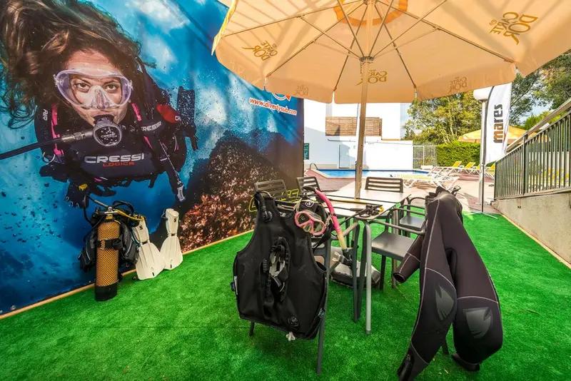 Espace extérieur aménagé avec des sièges et du matériel de plongée.