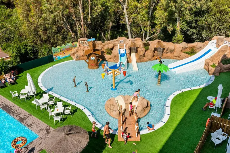 Vue aérienne d'une piscine pour enfants avec toboggans et décorations colorées.