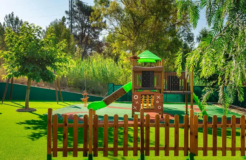 Une aire de jeux colorée avec une structure en plastique et un sol amortissant.
