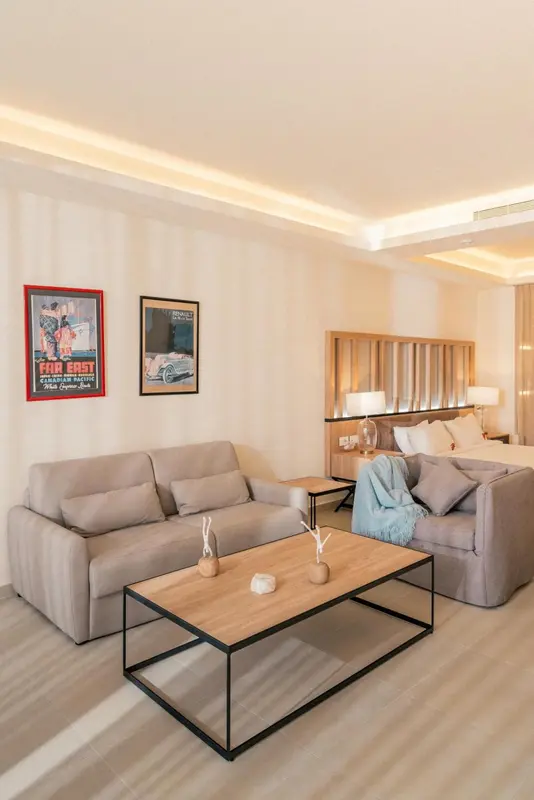 Un salon clair avec canapés gris et une table basse en bois.