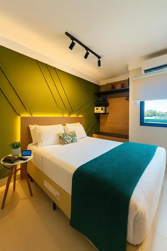 Chambre moderne avec un lit blanc et des accents de couleur vive.