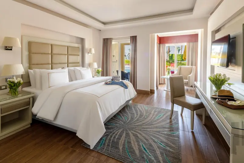 Une chambre lumineuse avec un grand lit et un coin salon.