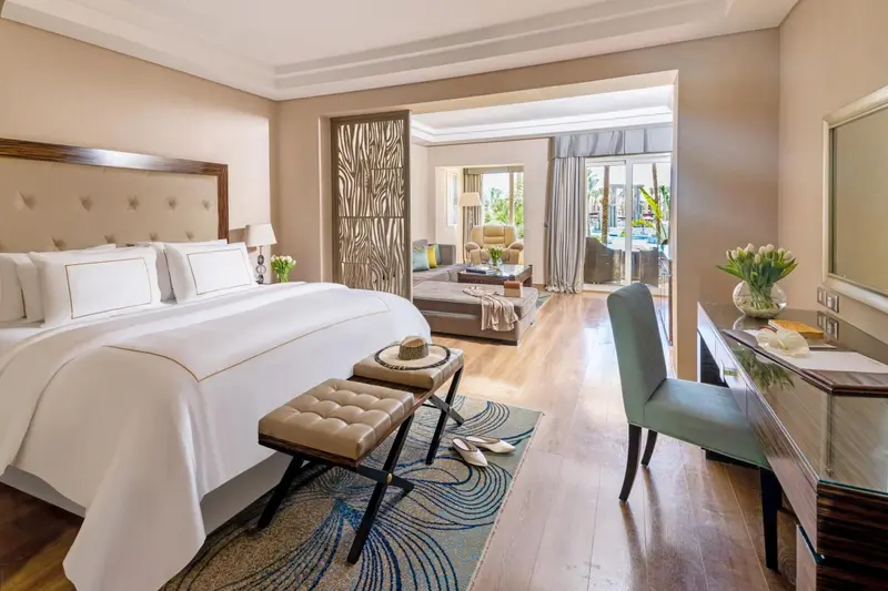Une chambre lumineuse avec un grand lit et un espace salon.