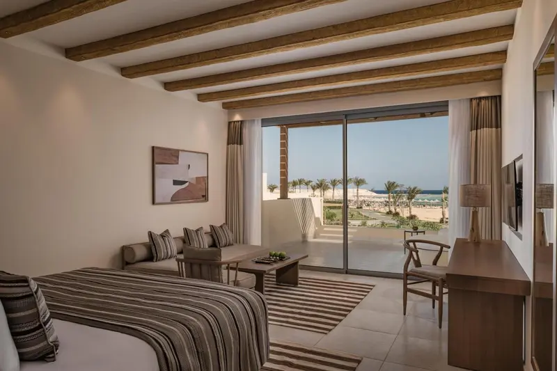 Une chambre lumineuse avec un lit et un canapé donnant sur une vue sur la mer.