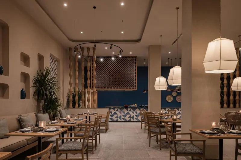 Une salle de restaurant lumineuse avec des tables dressées et une décoration soignée.