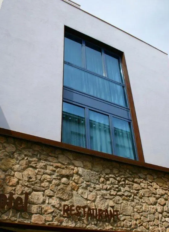 Façade d'un bâtiment avec une grande fenêtre et un restaurant au rez-de-chaussée.