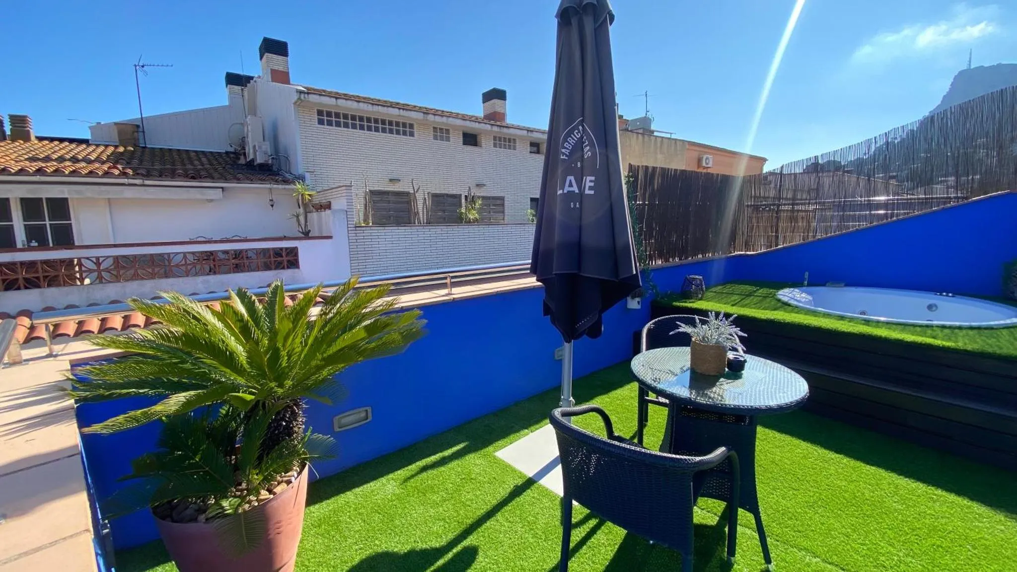 Terrasse avec mobilier de jardin et végétation.
