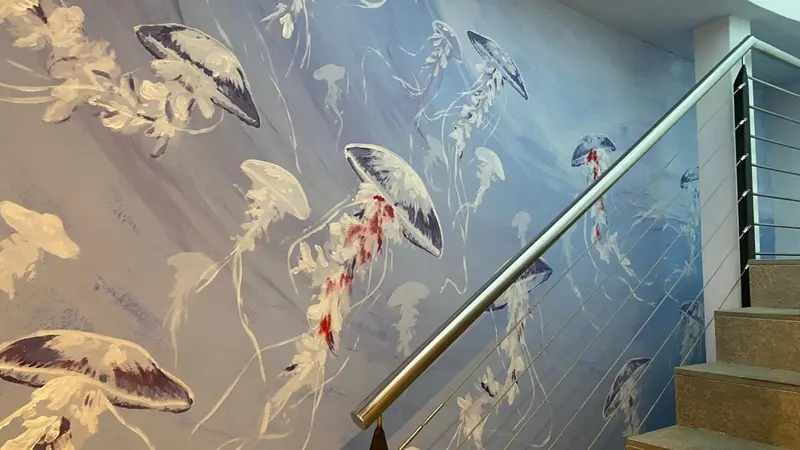 Décor mural représentant des méduses le long d'un escalier.