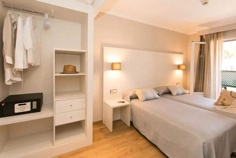 Une chambre lumineuse avec un grand lit et un espace de rangement.