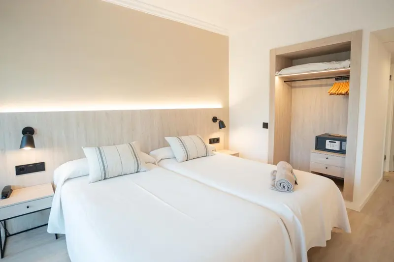 Une chambre lumineuse avec un grand lit et un placard intégré.