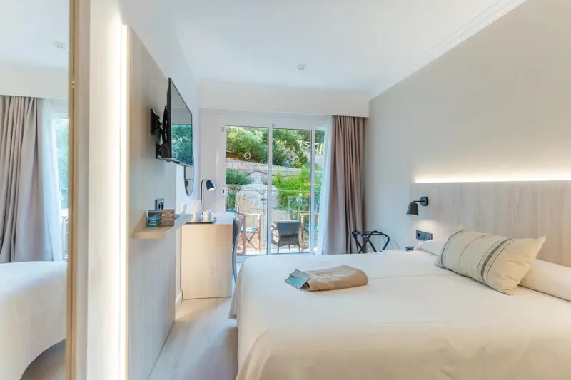 Une chambre lumineuse avec un grand lit et un accès à une terrasse.