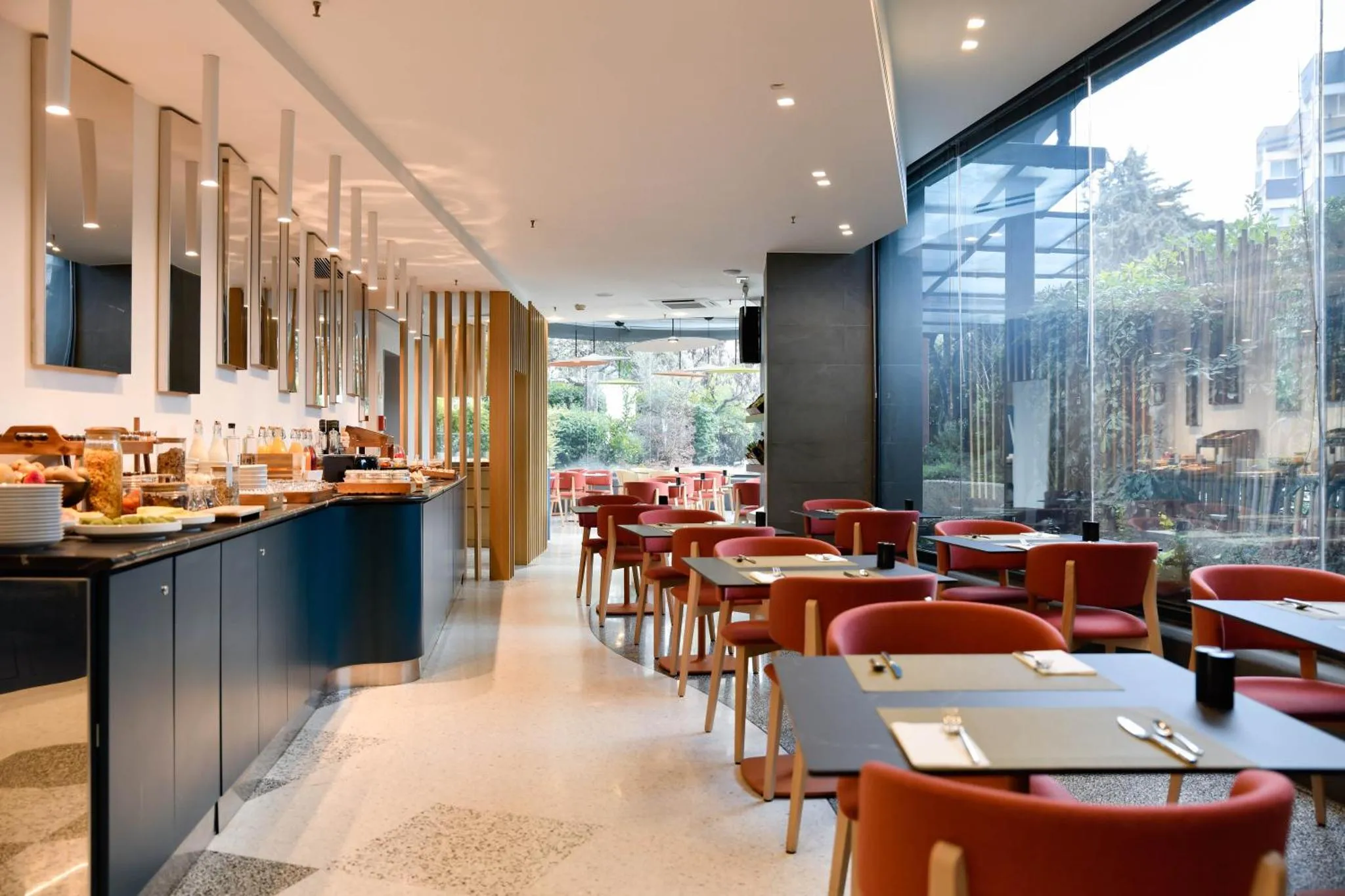 Une salle lumineuse avec un buffet et des tables pour le petit-déjeuner.