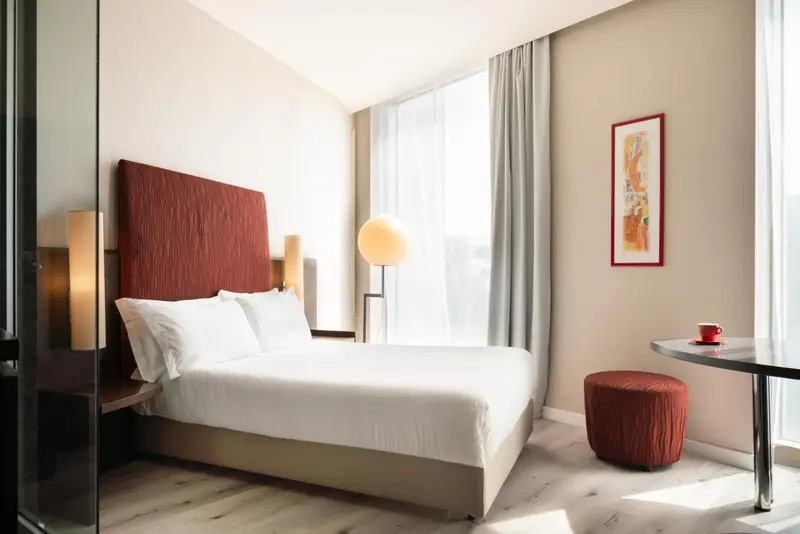 Une chambre lumineuse avec un grand lit et une décoration moderne.