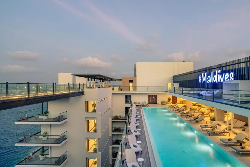 Vue aérienne d'un hôtel avec une longue piscine et des transats.