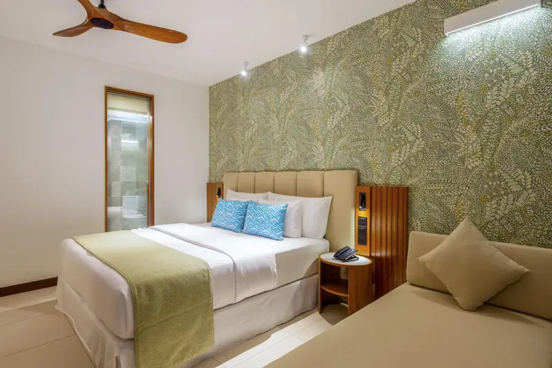 Une chambre lumineuse avec un grand lit et un coin lecture.
