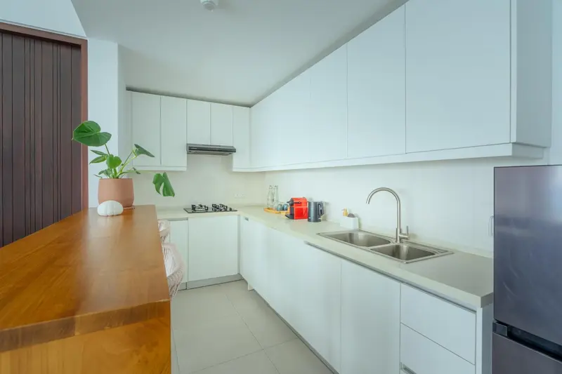 Cuisine moderne et lumineuse avec un plan de travail en bois.