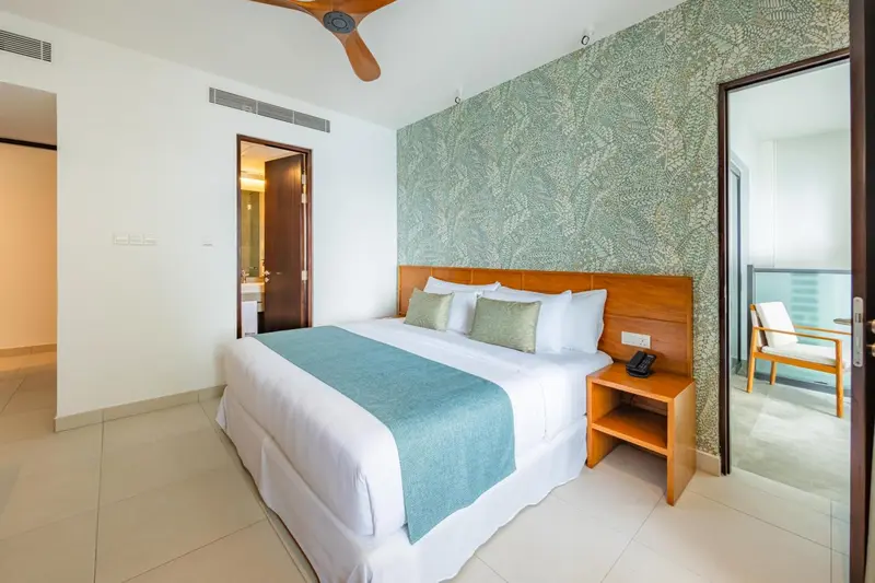 Une chambre lumineuse avec un grand lit et une décoration sobre.