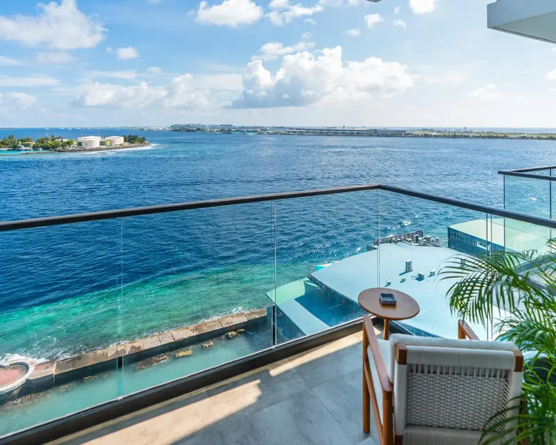 Vue sur la mer depuis un balcon avec mobilier d'extérieur.