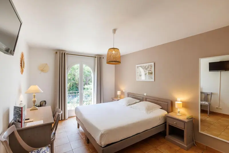 Une chambre lumineuse avec un grand lit et un bureau.