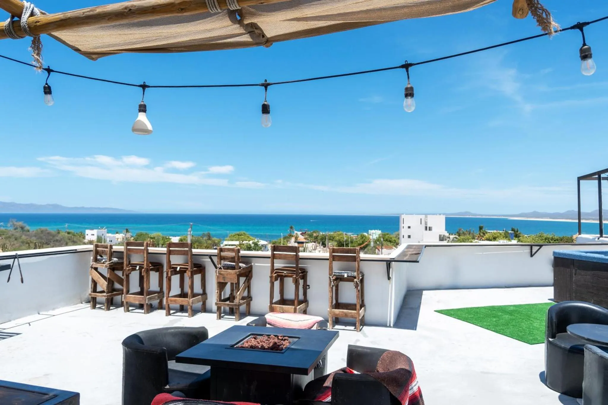 Terrasse aménagée avec mobilier de jardin et vue sur la mer.