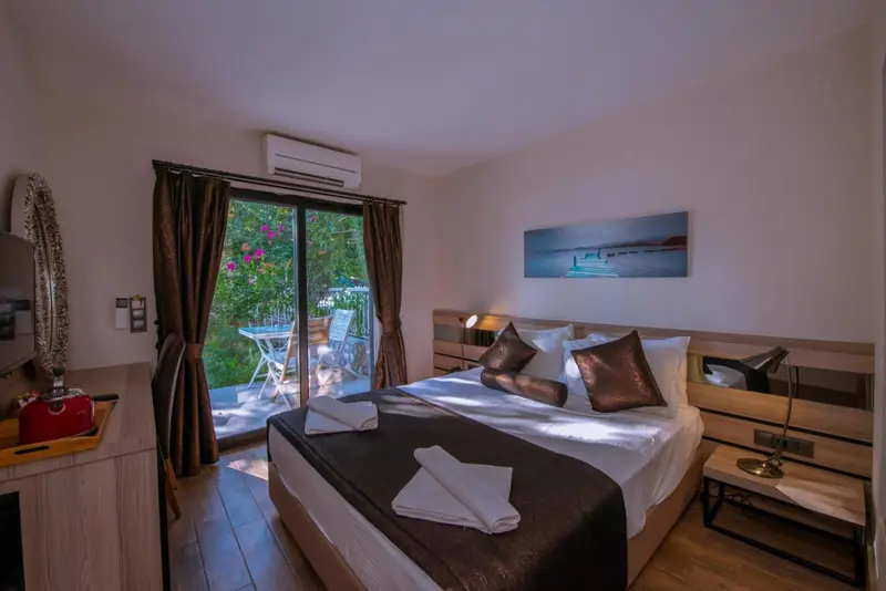 Une chambre avec un grand lit et un accès à une terrasse.