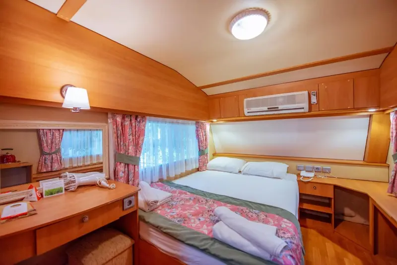 Une chambre lumineuse avec un lit double et un bureau.