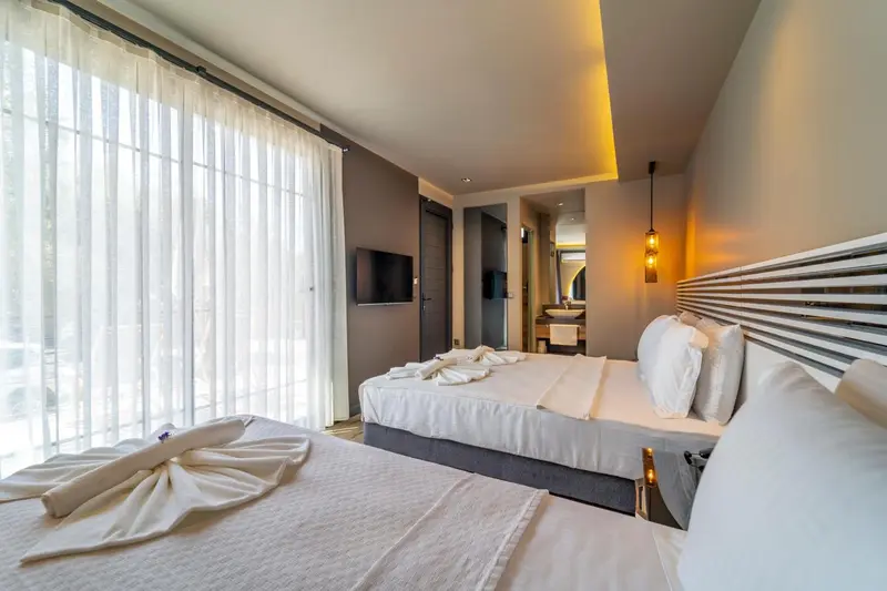 Une chambre lumineuse avec un grand lit et une vue sur l'extérieur.