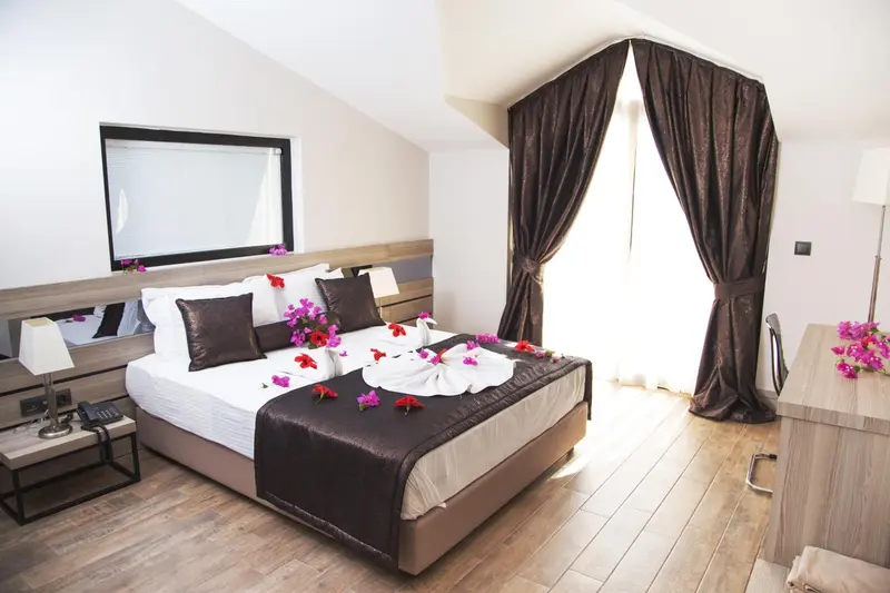 Une chambre décorée avec un lit à baldaquin et des fleurs.