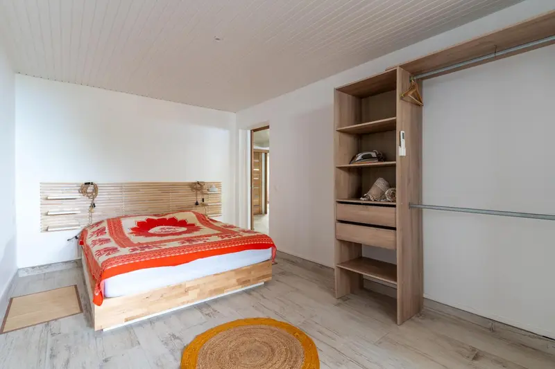 Une chambre lumineuse avec un grand lit recouvert d'une courtepointe colorée.