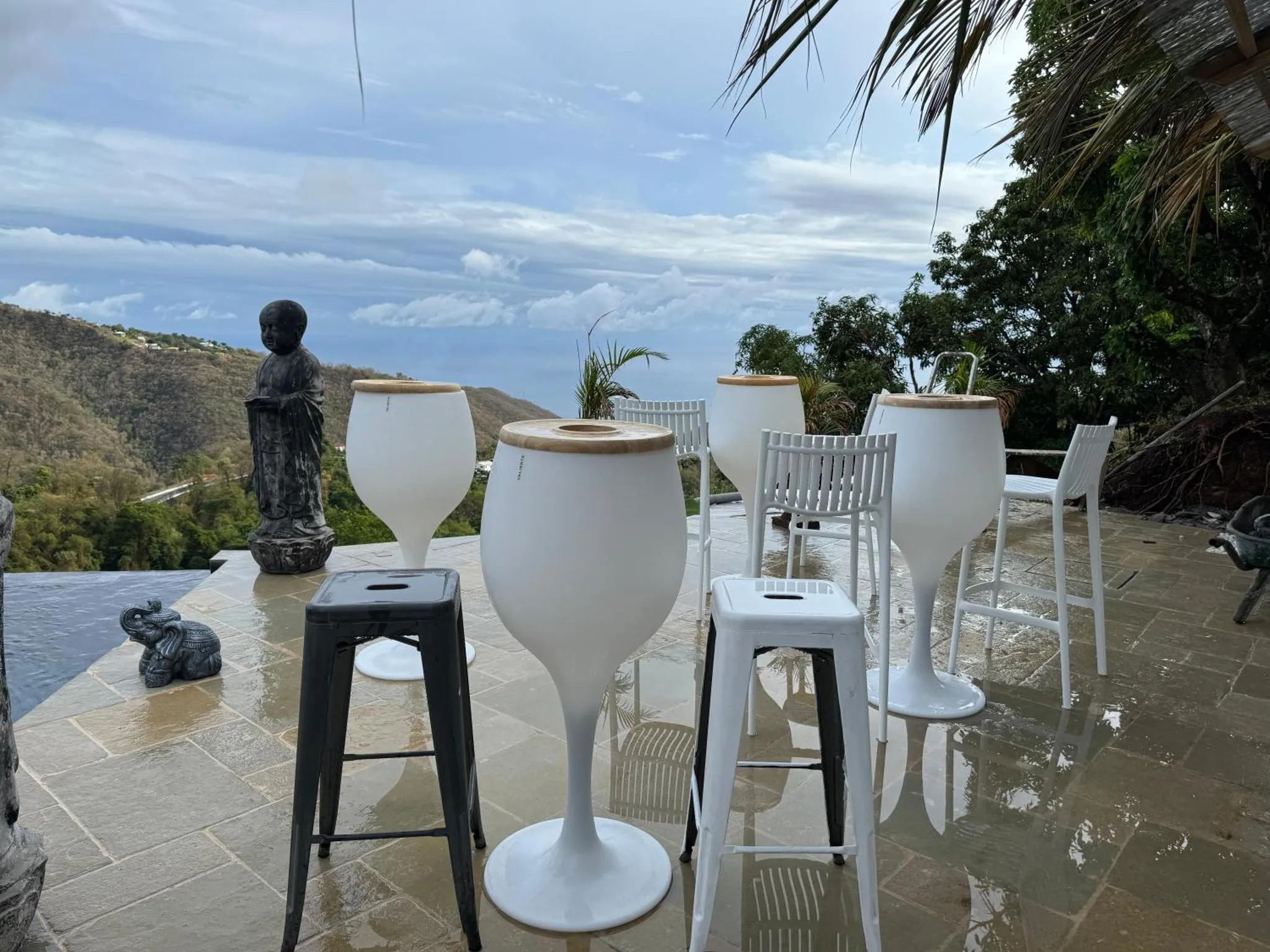 Terrasse avec tables hautes et vue sur les montagnes.