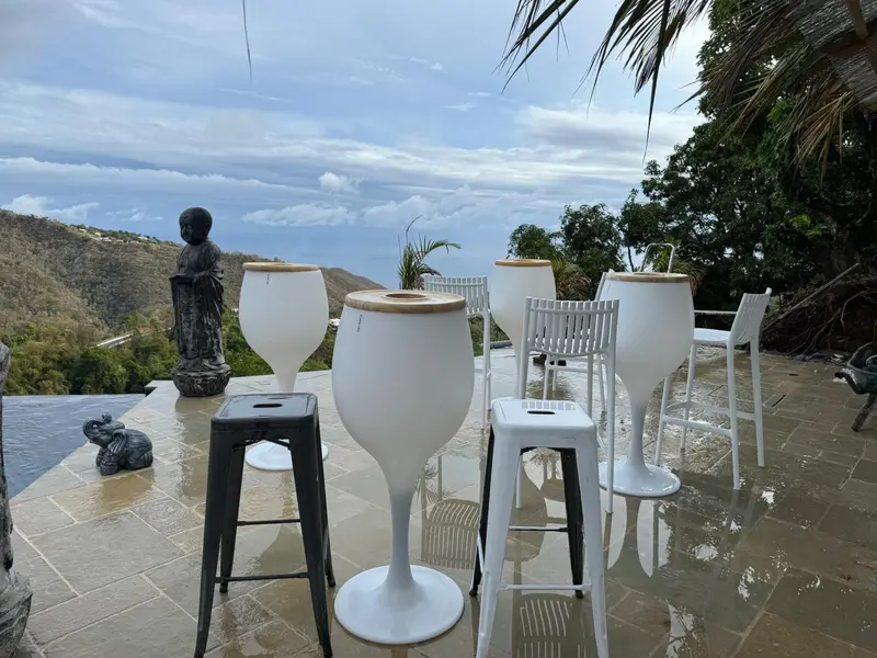 Terrasse avec tables hautes et vue sur les montagnes.