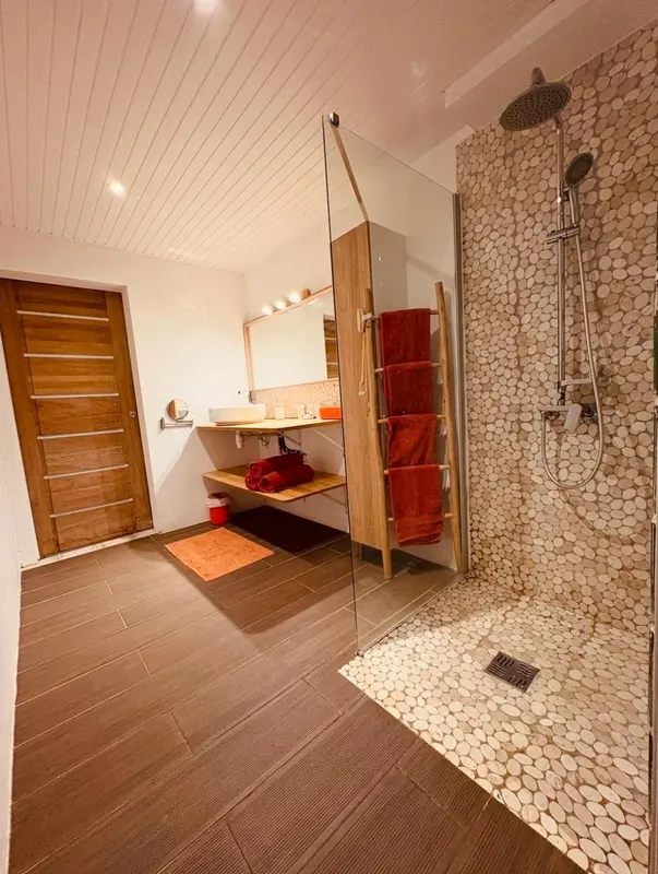 Une salle de bain moderne avec douche à l'italienne et décoration en galets.