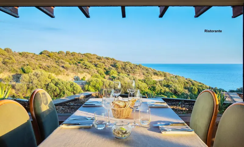 Une table dressée en terrasse offre une vue sur la côte et la mer.