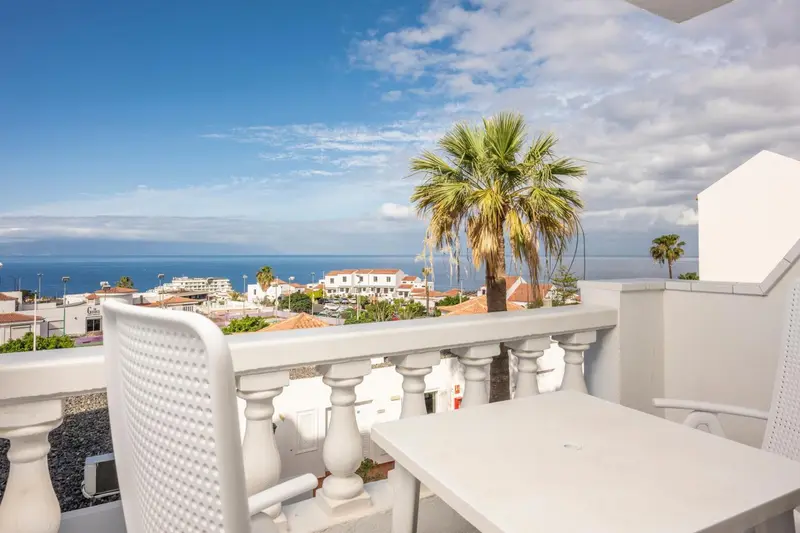 Vue dégagée sur la mer depuis une terrasse ensoleillée.