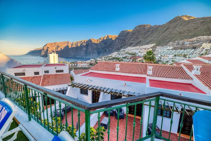 Vue aérienne d'un complexe hôtelier avec des toits en tuiles rouges et une terrasse ensoleillée.