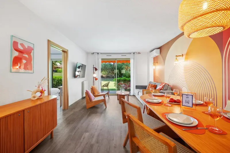 Espace de vie lumineux avec coin repas et canapés.