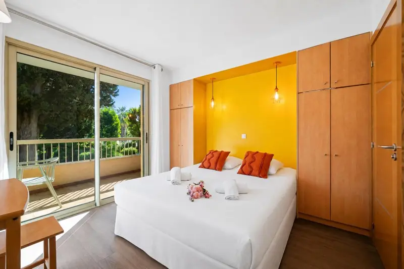 Une chambre lumineuse avec un grand lit et un accès à une terrasse.