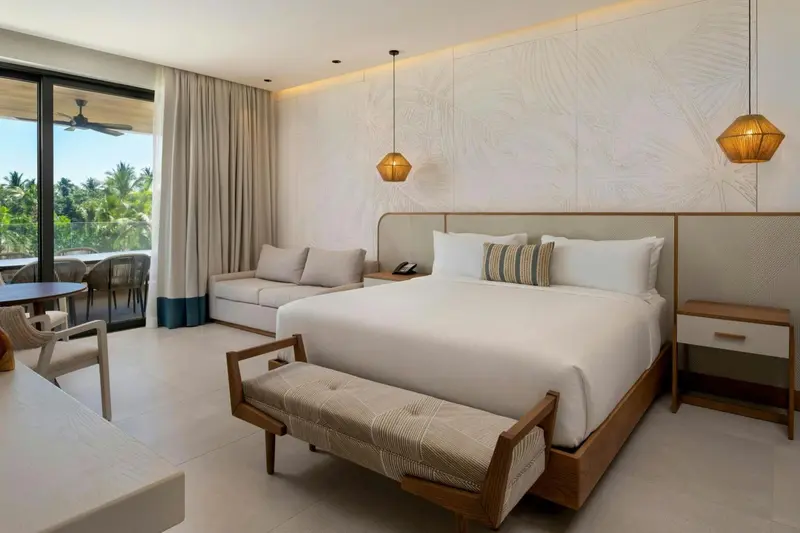 Une chambre lumineuse avec un grand lit et un espace détente.