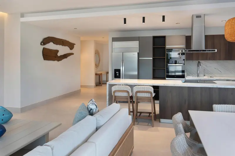Un espace de vie lumineux combine un coin salon et une cuisine moderne avec un îlot central.