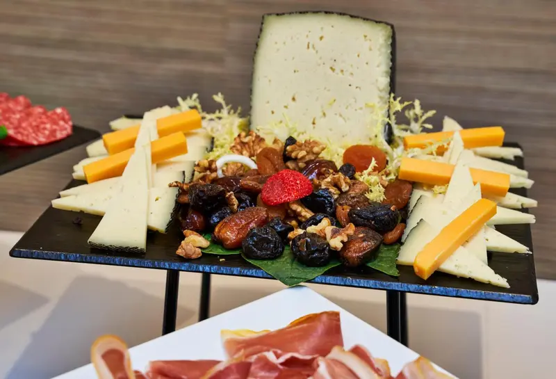 Assortiment de fromages, charcuteries, fruits secs et salade.