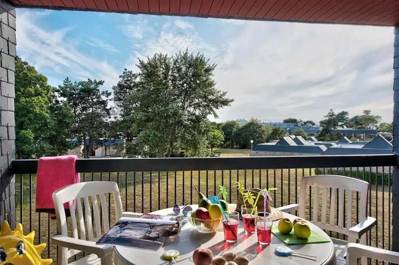 Une table avec des fruits et des boissons sur une terrasse ensoleillée.