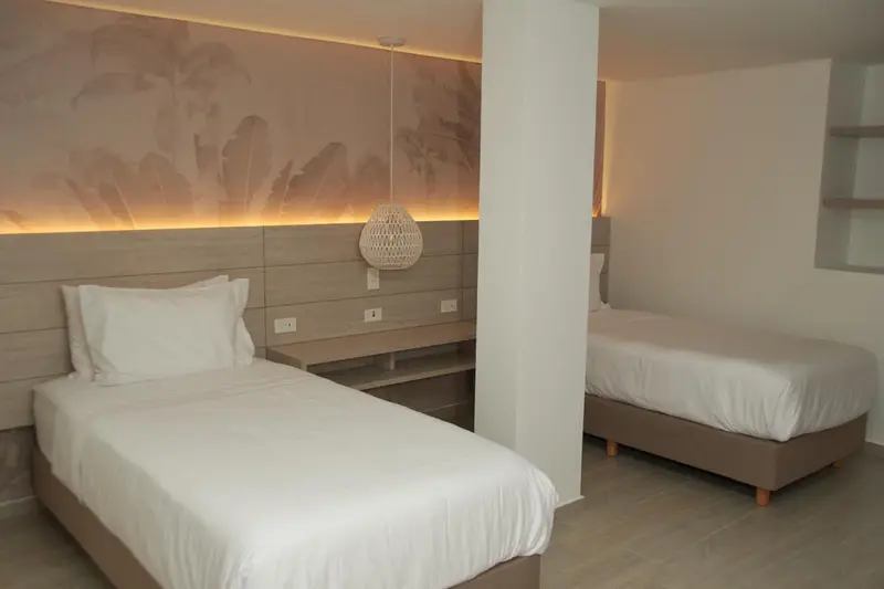 Deux lits simples dans une chambre lumineuse et minimaliste.