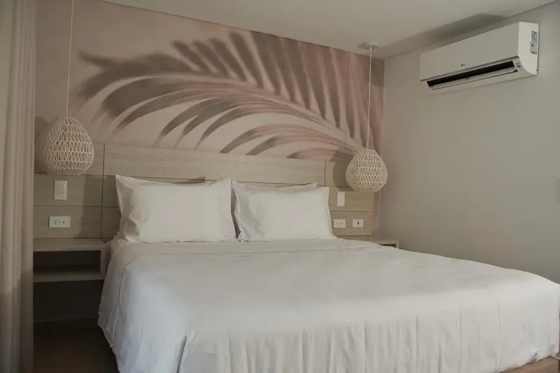Une chambre lumineuse avec un grand lit recouvert de draps blancs.