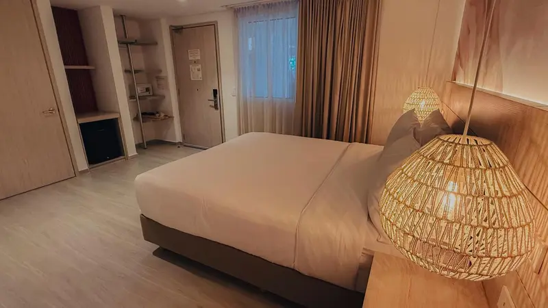 Une chambre lumineuse avec un grand lit et une décoration en bois.