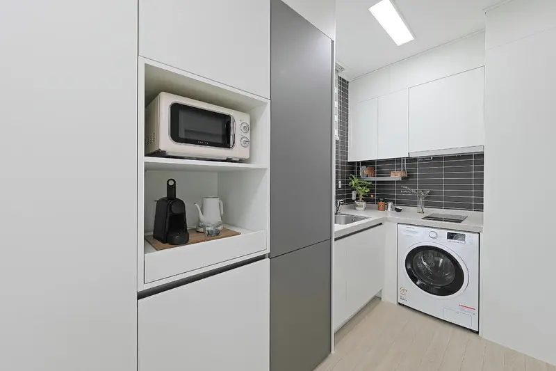 Une kitchenette moderne avec des appareils électroménagers intégrés et un plan de travail.