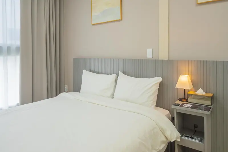 Une chambre lumineuse avec un grand lit recouvert de draps blancs.