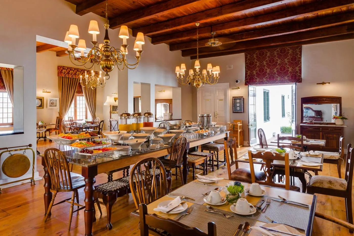 Une salle lumineuse avec de longues tables dressées pour un repas.