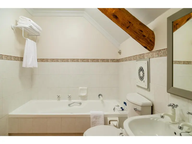 Une salle de bain lumineuse avec baignoire et lavabo.