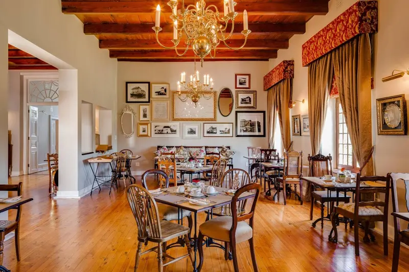 Une salle lumineuse avec des tables dressées pour le repas.